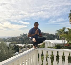 A man is doing yoga on the balcony