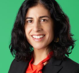 A woman with long black hair wearing a red neck tie.